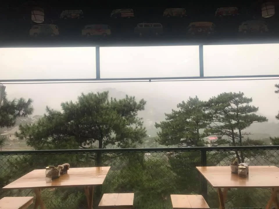 Open-air café seating looking into Baguio mist and pine trees